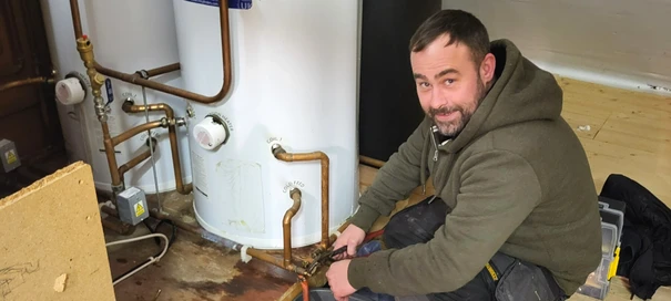 A heating Engineer is repairing a boiler